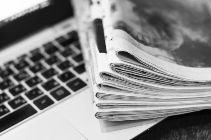 Journaux pliés posés sur le clavier d’un ordinateur portable